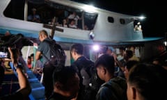 Father Robert Reyes and others board the Christmas convoy vessel bearing the Pilgrim Mission Cross