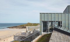 A close-up of the modern Tate St Ives extension with the sandy beach and sea in the distance to the left