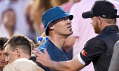 Andrew Flintoff wearing a blue bucket hat, with tape on his nose and scars around his nose and mouth, in a match crowd