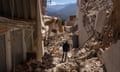 A man walks in the rubble of collapsed buildings in Moulay Brahim, Morocco. 
