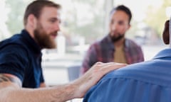 Mid adult man comforts friend during therapy session.