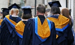 The backs of students wearing cap and black gowns with blue and orange silk