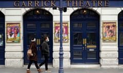 Pedestrians walk past the closed doors at the entrance to the Garrick Theatre in London during the coronavirus lockdown