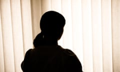 Silhouette of a woman against blinds