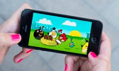 Woman playing Angry Birds game on an Apple iPhone 5