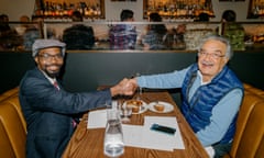 Don and Atam shaking hands over a restaurant table