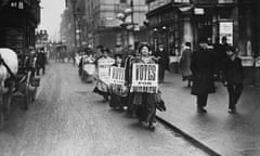 Suffragettes walk along a London street wearing sandwich boards demanding that women be given the vote, 1912.