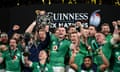 Johnny Sexton of Ireland lifts the Six Nations trophy as James Bryan lifts the Triple Crown trophy after winning the Six Nations with a grand slam.