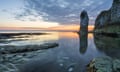 The first glow of sunrise highlights the bank of cloud behind the prominent sea stack at Selwicks Bay on the Yorkshire coast.<br>2E3RJEG The first glow of sunrise highlights the bank of cloud behind the prominent sea stack at Selwicks Bay on the Yorkshire coast.