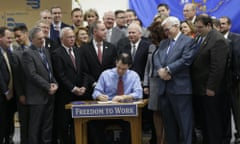 Wisconsin Gov. Scott Walker signs a right-to-work bill into law Monday, March 9, 2015 at Badger Meter in Brown Deer, Wis. The new law, which takes effect immediately, makes Wisconsin the 25th right-to-work state and the first to do it since Michigan and Indiana in 2012. (AP Photo/Milwaukee Journal-Sentinel, Mike De Sisti)