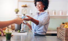 Female employee taking payment from customer<br>Cropped shot of female employee taking payment from customer, focus on female hands giving credit card for juice bar payment.