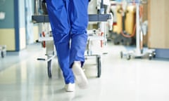 Legs of medic running with gurney along hospital corridor<br>DKFWG8 Legs of medic running with gurney along hospital corridor