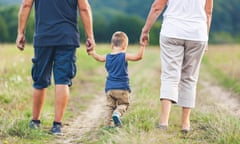 Grandparents on a walk outside with their grandchild.