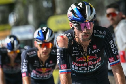 Primoz Roglic crosses the line with visible injuries sustained in another crash.