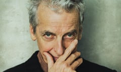 Peter Capaldi, head and shoulder shot, holding his hand to his mouth and looking up; wearing a black jacket and brown shirt