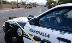 Police car with yellow caution tape is parked across a wide flat boulevard.