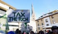 Demonstrators hold a homemade sign saying Tax the Rich in downtown Davos, Switzerland, on January 14.