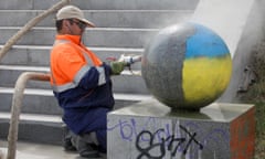 A worker washes off graffiti in the colours of the Ukrainian flag in central Yekaterinburg, Russia
