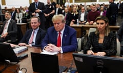 man in blue suit and red tie with laywers either side in a courtroom