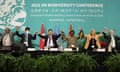 The top table of the Cop15 summit hold hands and raise them to celebrate the passing  of the deal on 19 December