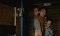Ben Aldridge, Kristen Cui and Jonathan Groff in Knock at the Cabin, peering around a door looking frightened