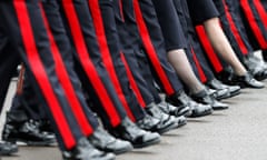 The lower legs of a row of male and female military personnel in uniform