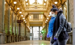 Women wearing masks pass by closed shops of Passage du Nord Gallery in Brussels city centre, Belgium.