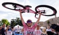 Tadej Pogacar celebrates winning stage 20 of the Giro d’Italia from Alpago to Bassano del Grappa, with his bike above his head