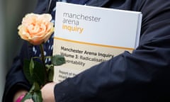 A copy of the inquiry report is seen as victims’ families listen to their representative Richard Scorer (not seen) as he makes a statement outside Manchester magistrates court