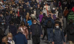 People, some of them without face masks to protect against coronavirus, walk along a street in Madrid, Spain.