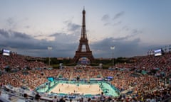 Beach volleyball underneath the Eiffel Tower in Paris at dusk.