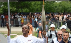 Snoop Dogg carries the Olympic torch through the streets of Saint-Denis.