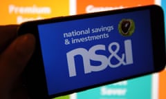 The National Savings & Investments logo on a phone and the website on a computer in the background