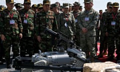 Robot dog with mounted gun surrounded by Chinese and Cambodian soldiers