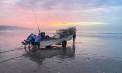 Fishers push a boat on the beach at San Juanico on the coast of north-west Mexico