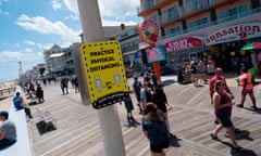 US-HEALTH-VIRUS-MARYLAND-BEACH<br>People walk past a sign advising about social distancing on the boardwalk during the Memorial Day holiday weekend amid the coronavirus pandemic on May 23, 2020 in Ocean City, Maryland. - The beach front destination has lifted its COVID-19 related beach and boardwalk restrictions May 9 and lodging restrictions May 14. The state of Maryland moved from a stay-at-home order to safe-at-home order May 15. (Photo by Alex Edelman / AFP) (Photo by ALEX EDELMAN/AFP via Getty Images)