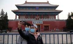 Tourists wearing face masks take a selfie outside of the Forbidden City in Beijing, China. The coronavirus has so far claimed at least 300 lives and infected more than 14,000 others.