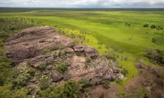 An aerial view of Ubirr rock formation and the surrounding savanna during the wet season, as seen from a helicopter over Kakadu national park