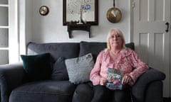 Barbara Slatford holding picture of grave with flowers around it