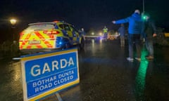 Police and emergency services parked on a road in the rain