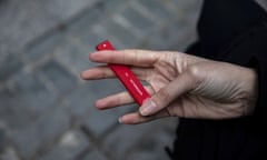 A woman holds a disposable vape device