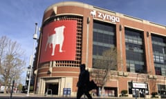 FILE - A pedestrian walks in front of a sign at Zynga in San Francisco, Tuesday, March 16, 2021. Take-Two Interactive, maker of Grand Theft Auto and Red Dead Redemption, is buying Zynga, maker of FarmVille and Words With Friends, in a cash-and-stock deal with an enterprise value of about $12.7 billion. Take-Two said Monday, Jan. 10, 2022, it anticipates $100 million in annual cost savings. (AP Photo/Jeff Chiu, File)