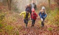 Family Walking Through Winter Woodland Having Fun