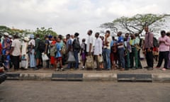 People in Lagos queue at a bus stop