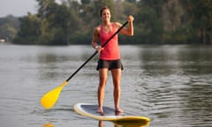 Woman paddleboarding on a calm lake.