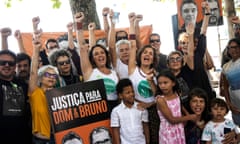 The relatives of British journalist Dom Phillips and activists hold a large poster with his image, left, and that of Indigenous activist Bruno Pereira, with the Portuguese message: "Justice for Dom and Bruno" at the one-year anniversary commemoration since their murders, in Rio de Janeiro, Brazil, Monday, June 5, 2023. The two were were killed in the Amazon's Vale do Javari area. (AP Photo/Bruna Prado)