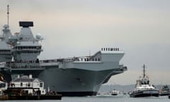 The Royal Navy’s aircraft carrier, HMS Queen Elizabeth, is towed by tugs as it arrives at Portsmouth.