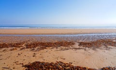 At low tide on East Chevington beach looking out to sea on a misty, cloudless spring morning.