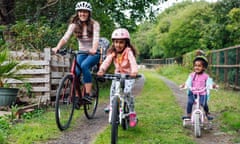 Mother and her two young daughters riding their bikes around a public park during the Covid-19 pandemic