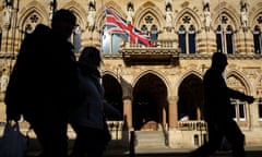 Shoppers walk past the Northampton Town Hall in the town centre